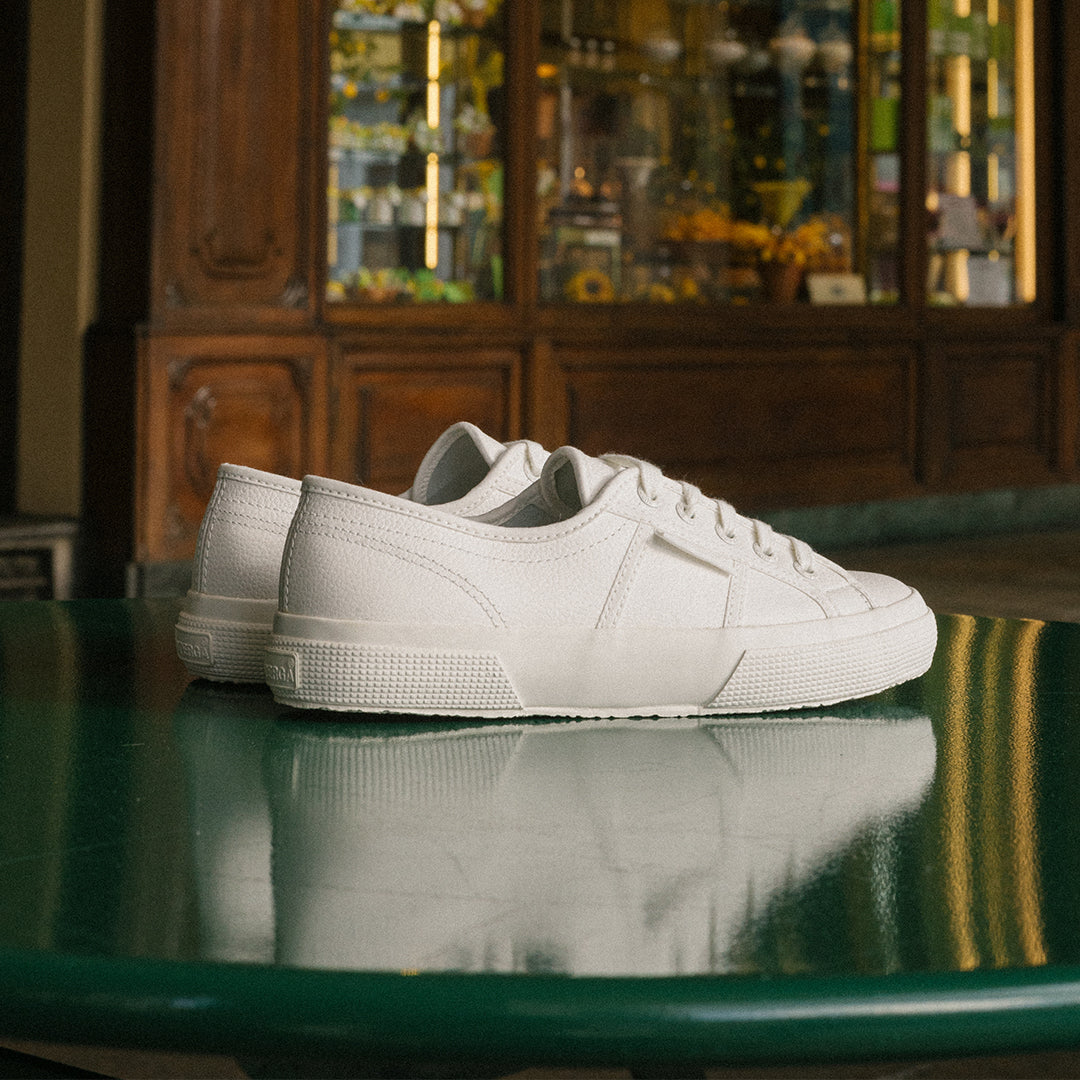 White leather Superga shoe displayed on green table