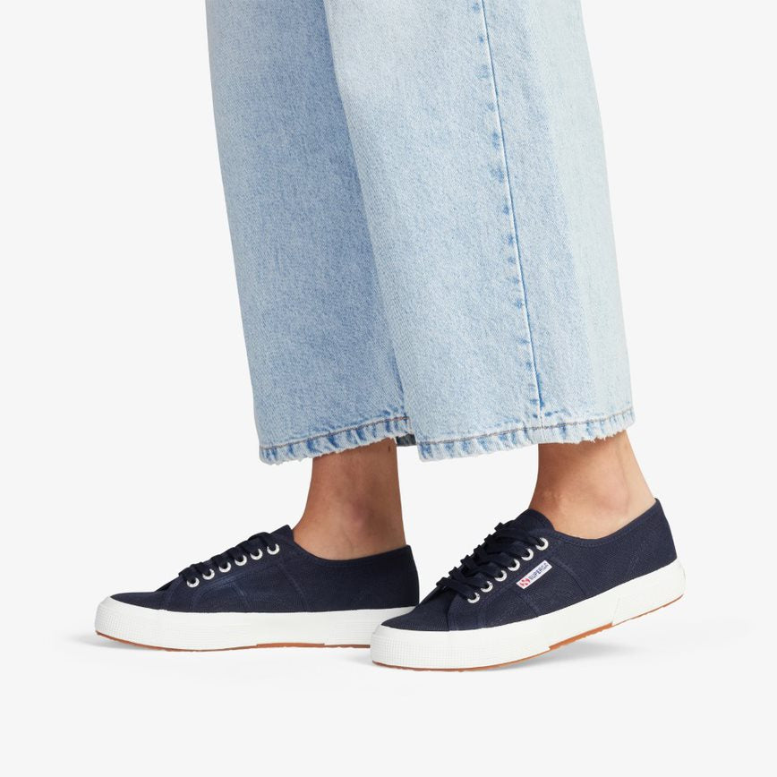 navy blue canvas sneakers with white rubber outer sole modelled with light wash denim jeans