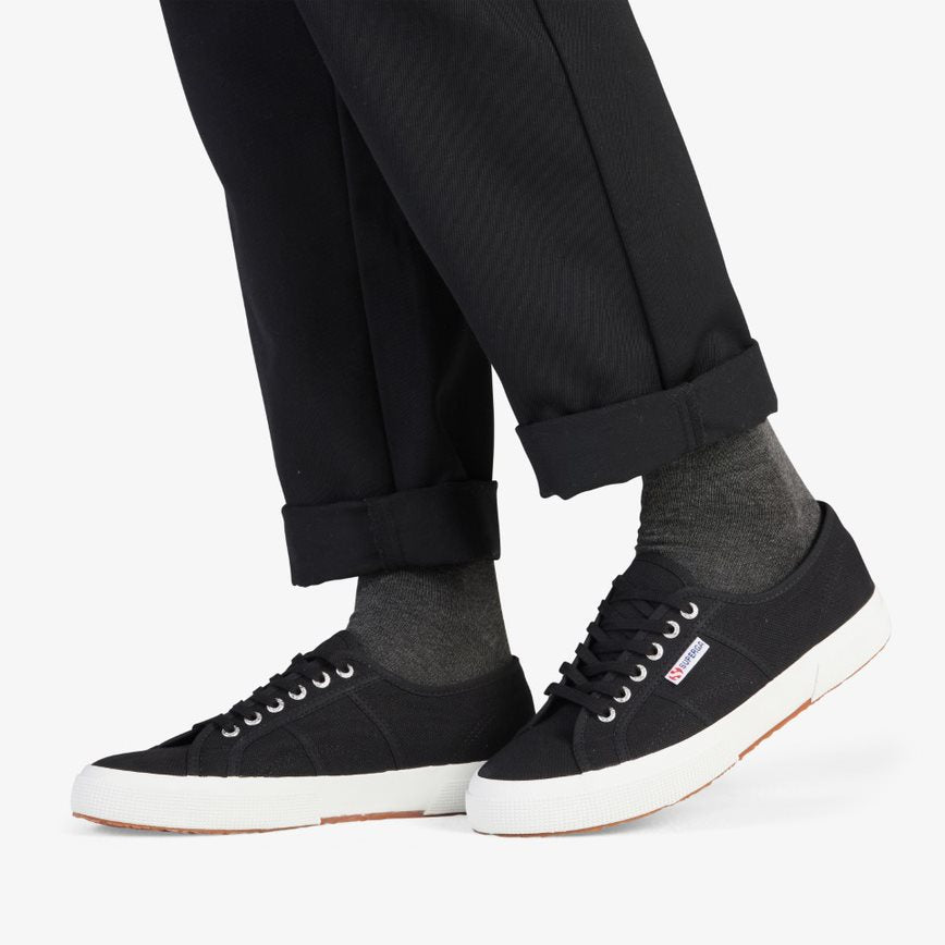 black canvas Superga shoes modelled with black socks and black pants